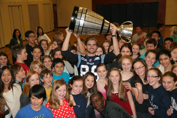 Toronto Argos’ Mike Bradwell, former pupil, shows off the Grey Cup to Northlea pupils and gym teacher  John Ellis, bottom centre, who remembers him as talented and a well-rounded kid.