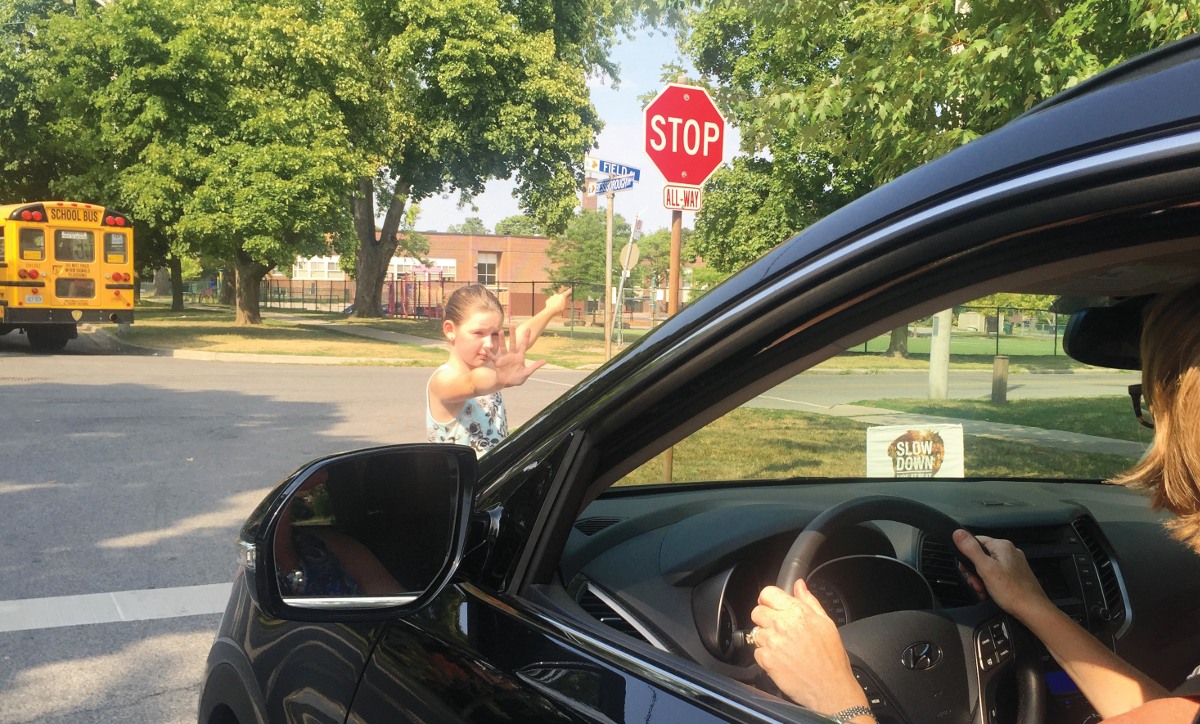 Anika Brophy reminds a driver near Bessborough school to slow down and stop.