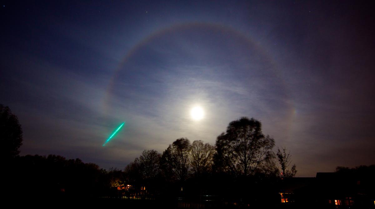 This a photo of a meteorite and a Moonbow around a Hunter's Moon. A moonbow is technically known as a 22? moon halo. The 22? Moon Halo is formed when moonlight passes through ice crystals in the atmosphere and are refracted approximately 22?.
