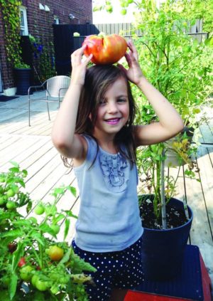 Mia shows off fruits of the roof garden.