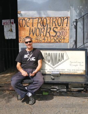 Tom Mourgas the “Iron Man” outside his shop on Canvarco. Photo by Karli Vezina