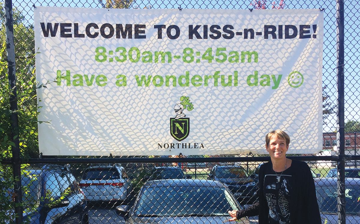 Valerie Cooke and her Kiss ‘n’ Ride banner. Photo By Janis Fertuck.