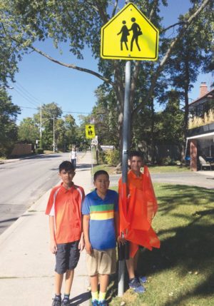 Arnav, Oliver and Quinlan with their orange flags. Photo By Janis Fertuck.