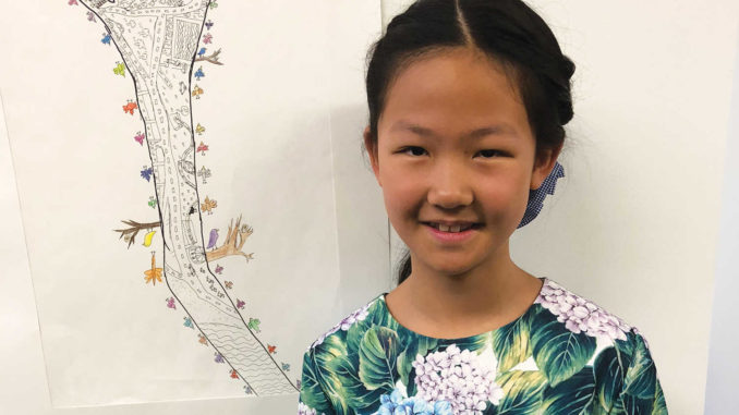 Vita Huang, 10, with her first prize drawing.