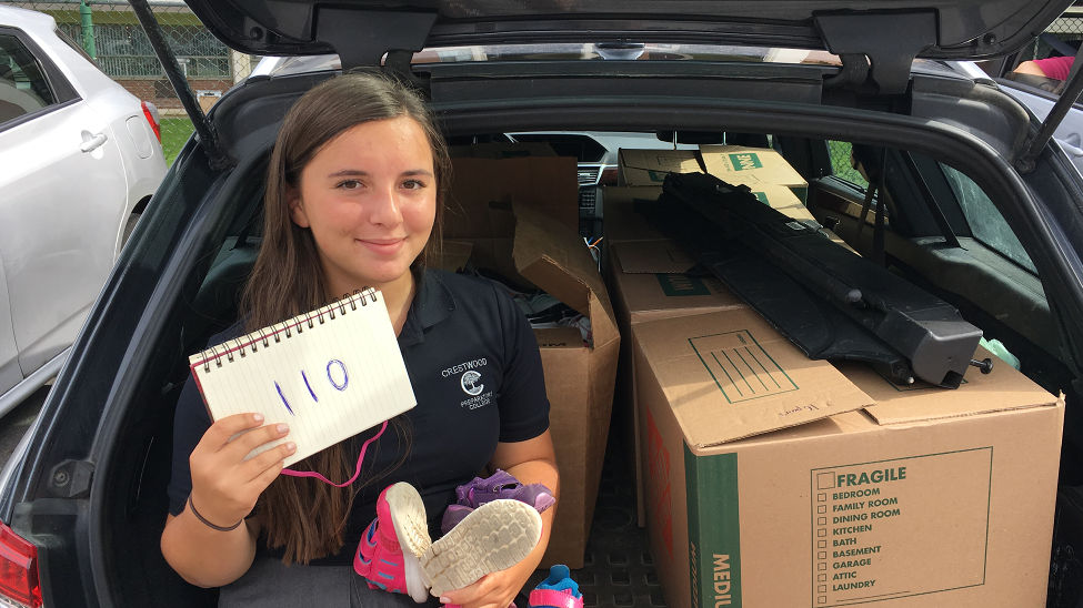 Caroline with her collection of 110 donated pairs of shoes.