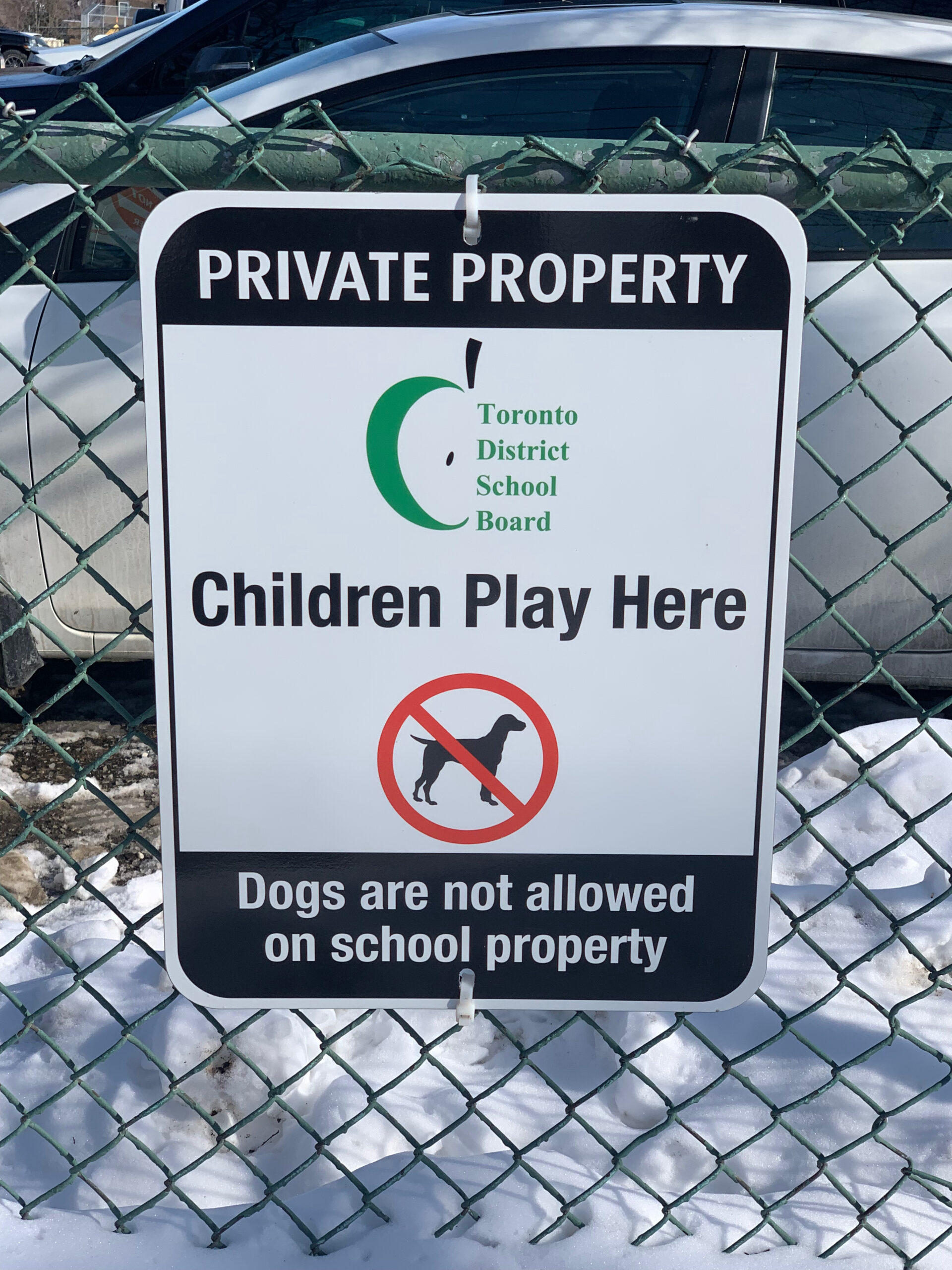 Photo of "Children Play here" sign, telling people not to have dogs on school property.