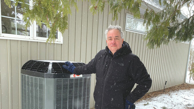 Leasider Tim Short beside a newly installed heat pump at his parents’ home. Photo Tim Short.