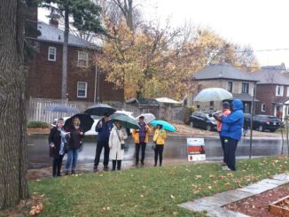 LHPS board member Susan Parr reads the biography of a fallen Leaside solider in front of his memorial sign and former home on Millwood Road.