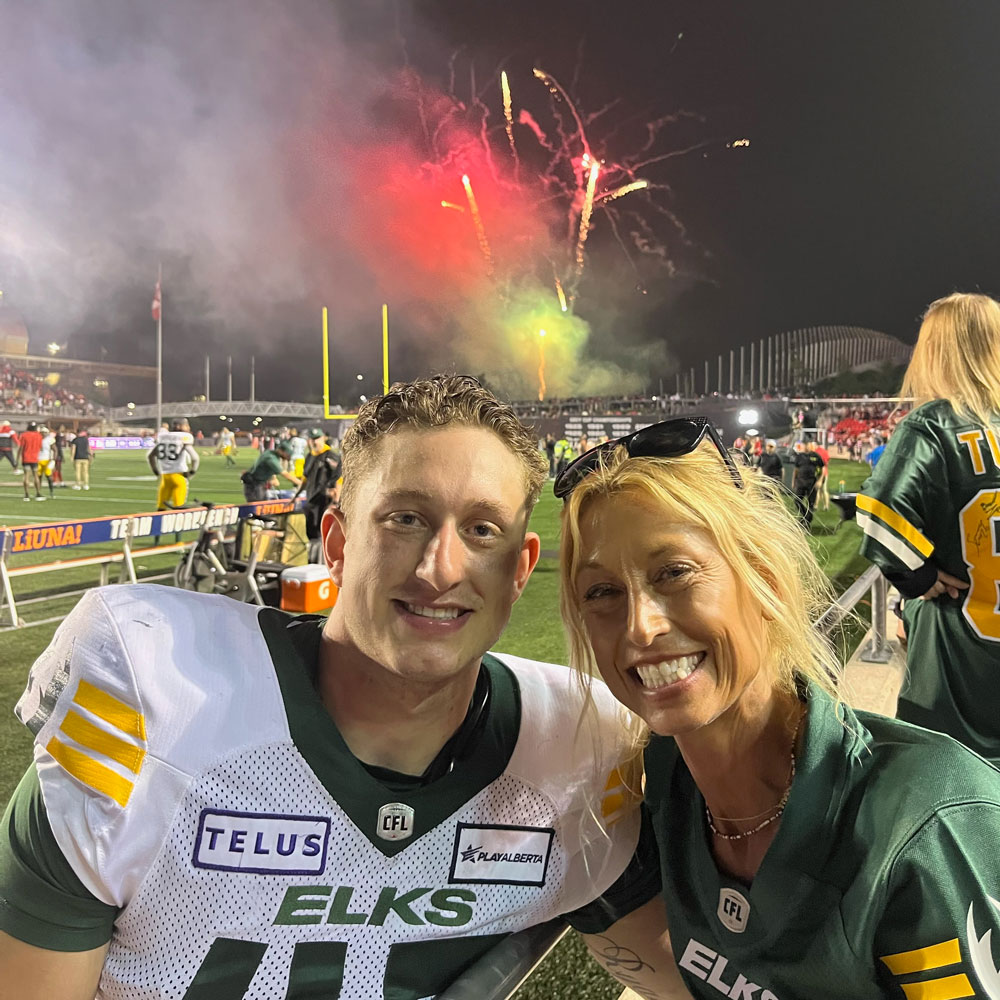 Peter Adjey and mom Laura celebrate after an Edmonton Elks’ win.